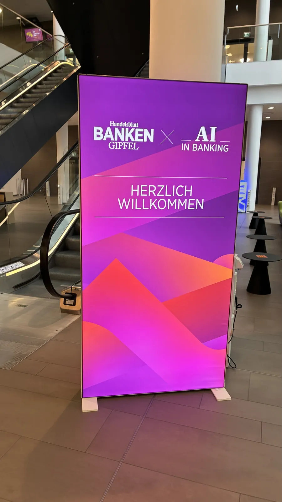 Willkommens-Display mit den Logos von Handelsblatt Banken-Gipfel und AI in Banking